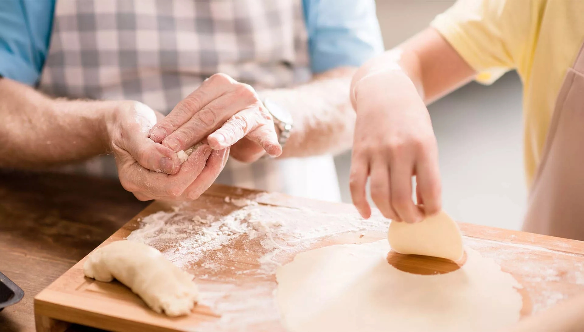 Two people mixing dough