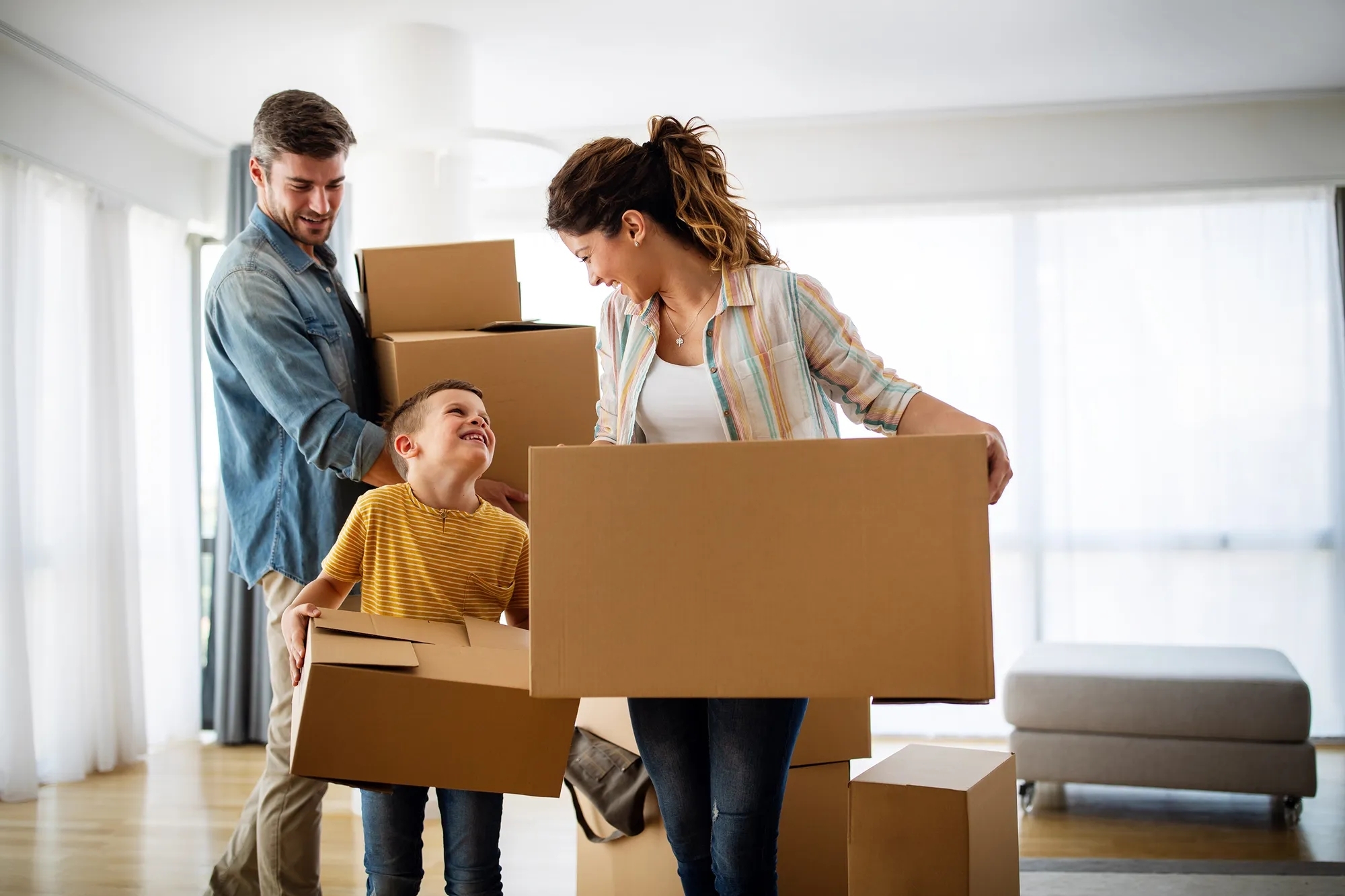 A family carrying boxes into a new house. 