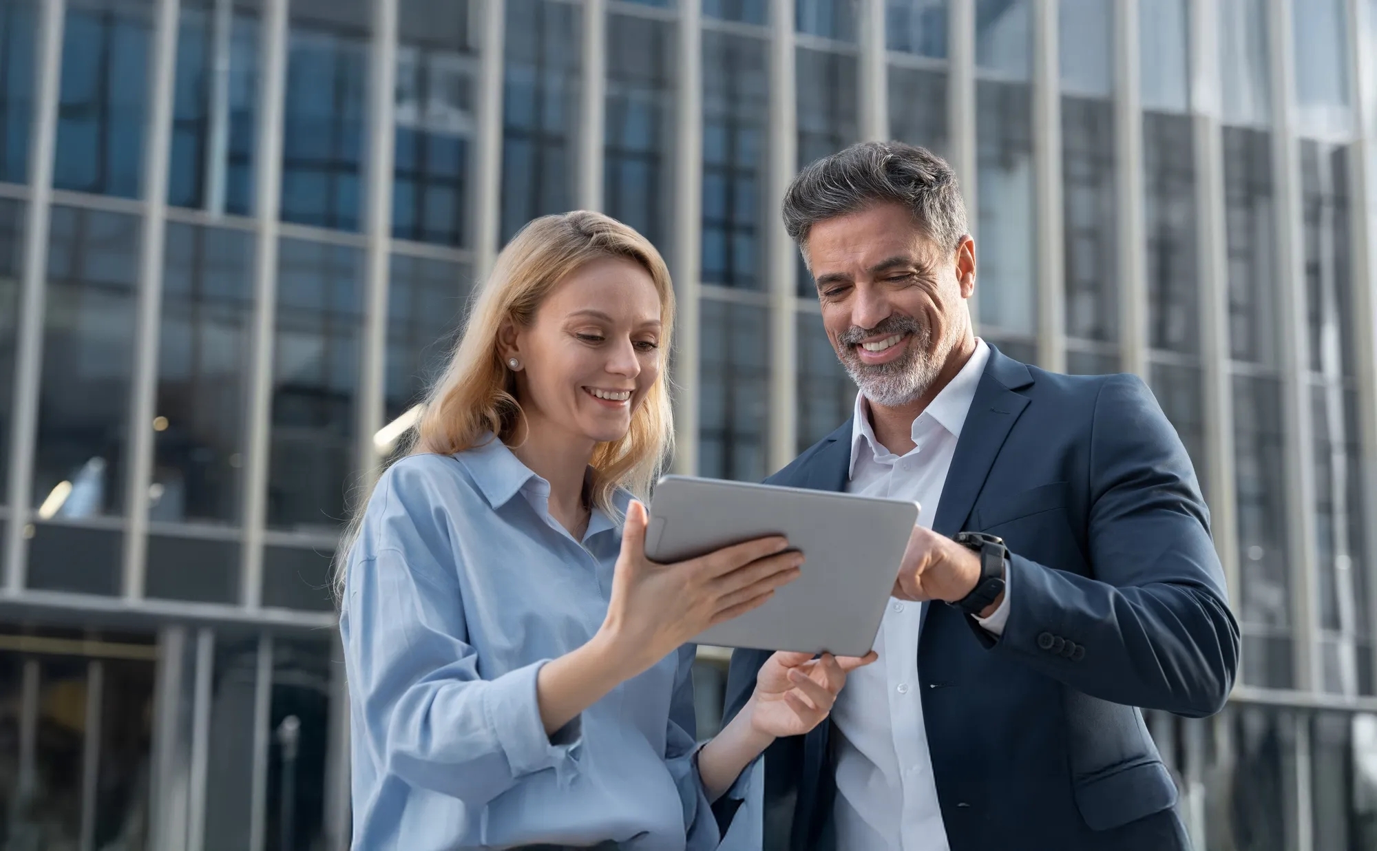 man and woman looking at tablet