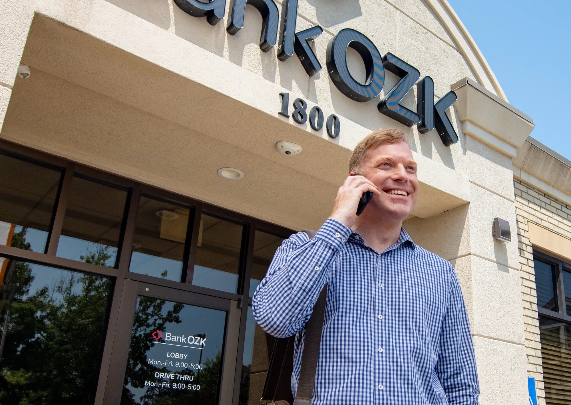 Man talking on phone outside of Bank OZK