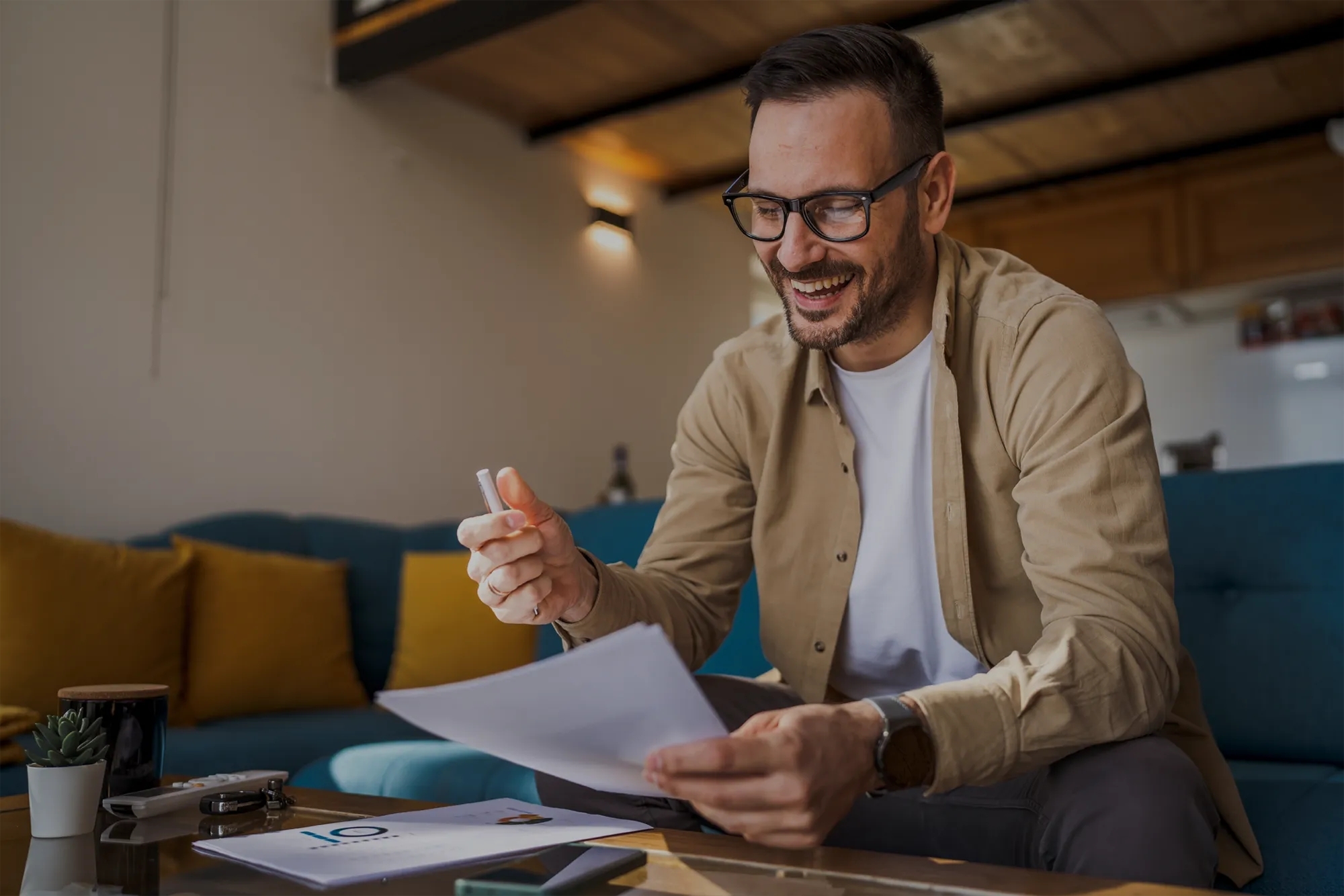 Man sitting on couch signing paper Man sitting on couch signing paper