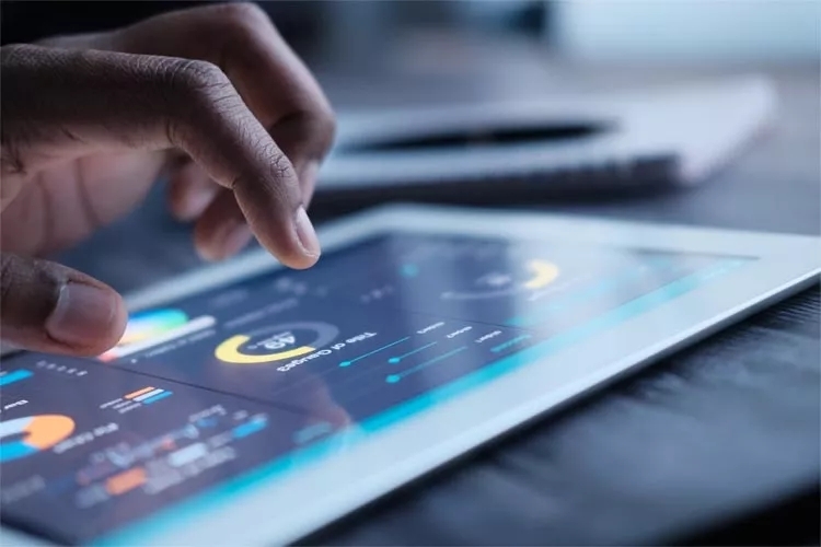 A hand interacting with a dashboard on a tablet. A hand interacting with a dashboard on a tablet.