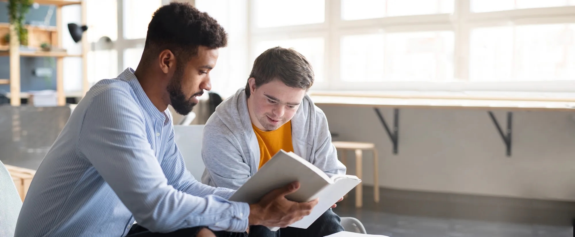 Man helping a young man read