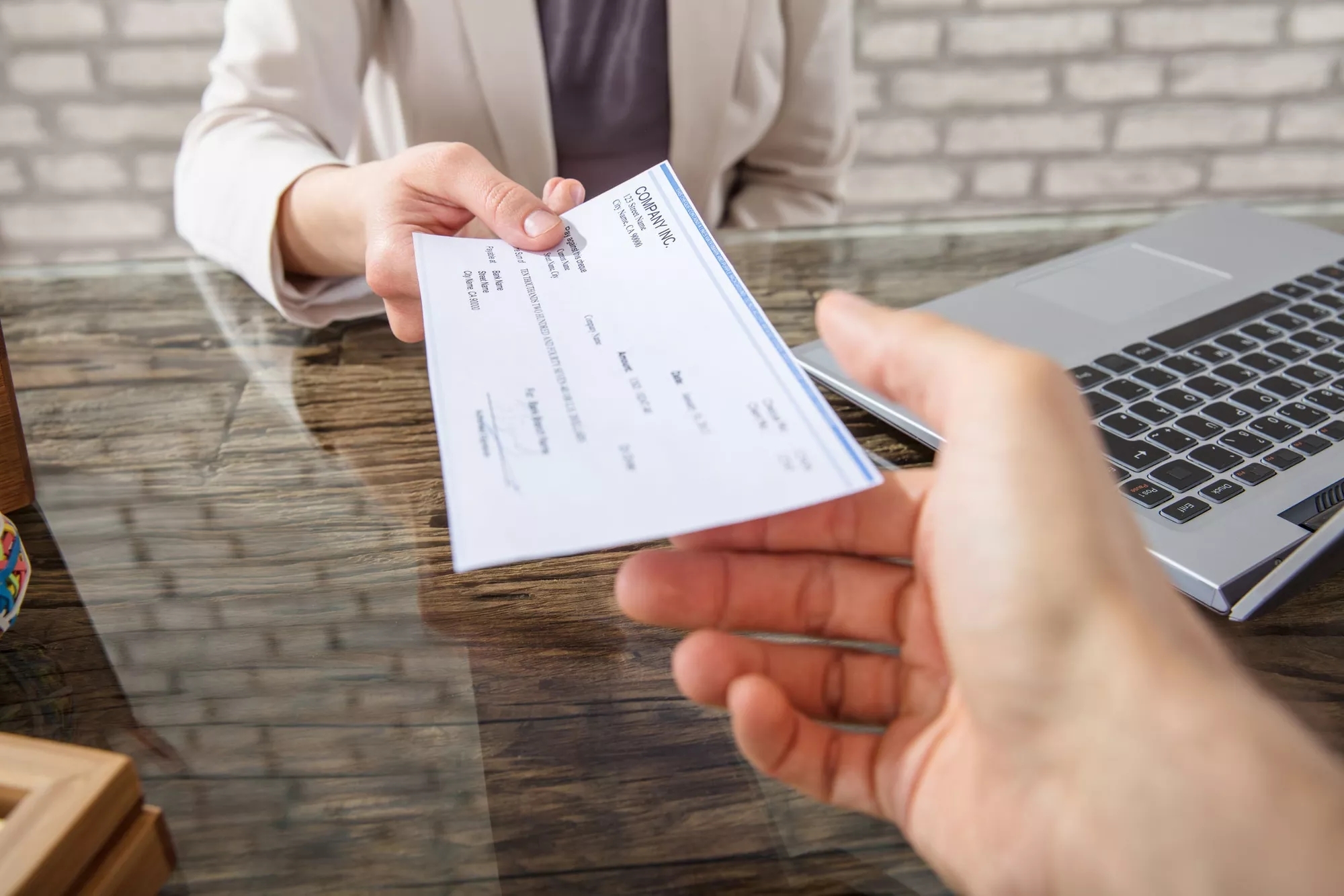 A person handing over a check to another person.