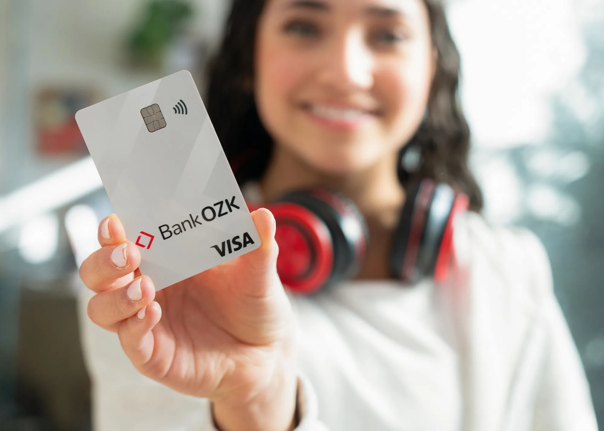 Woman holding Bank OZK debit card. 