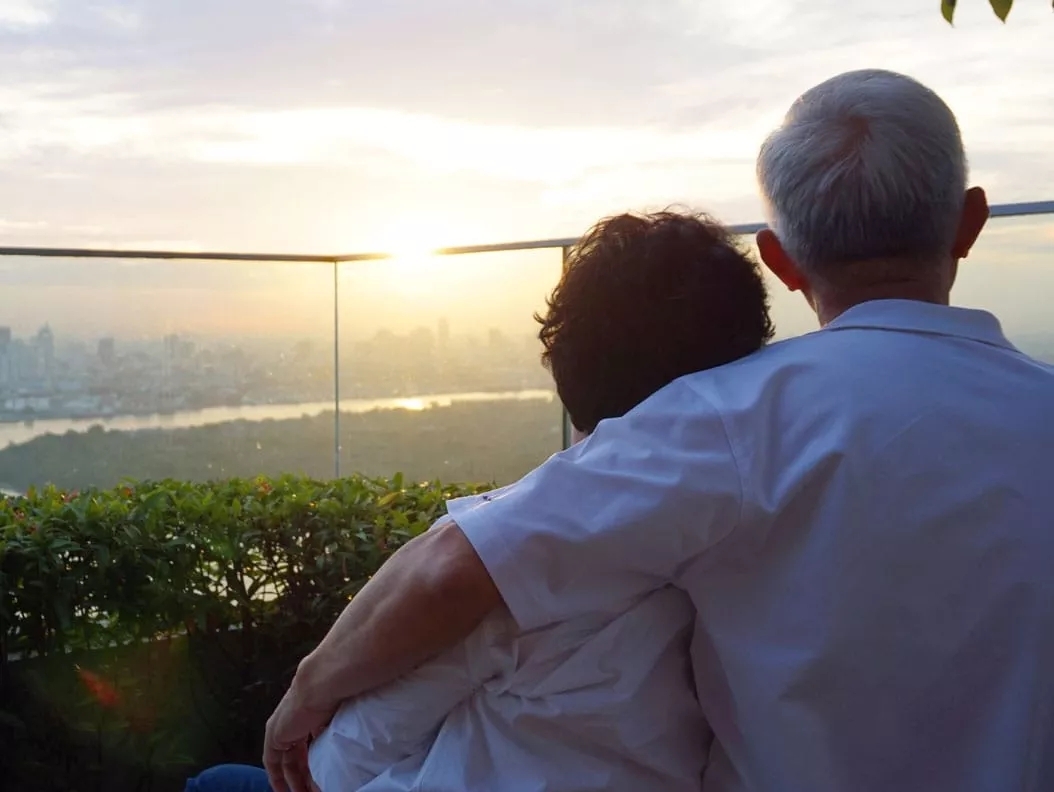 a couple standing and watching sunset