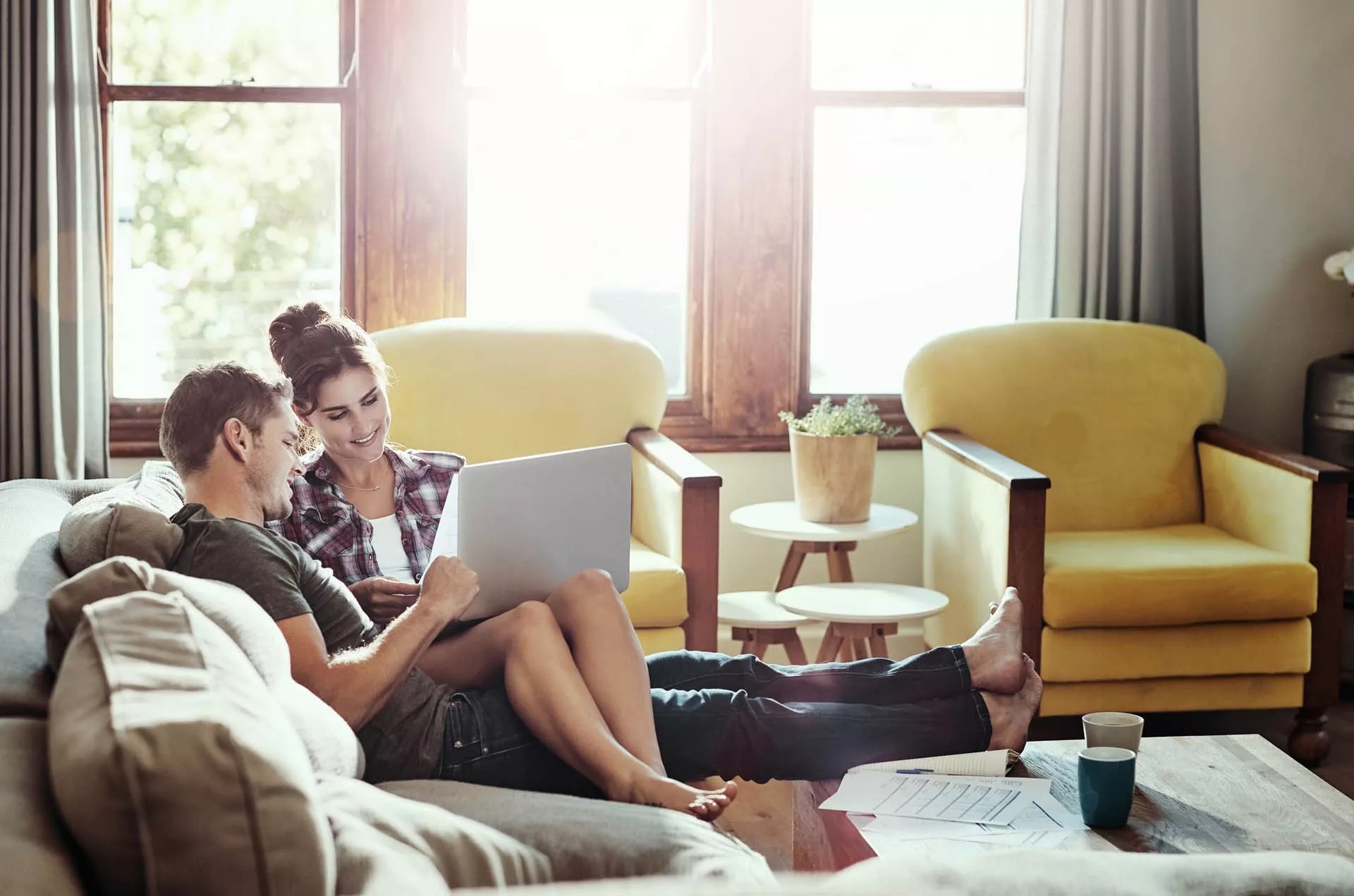 A couple sitting on a couch, viewing a laptop. A couple sitting on a couch, viewing a laptop.