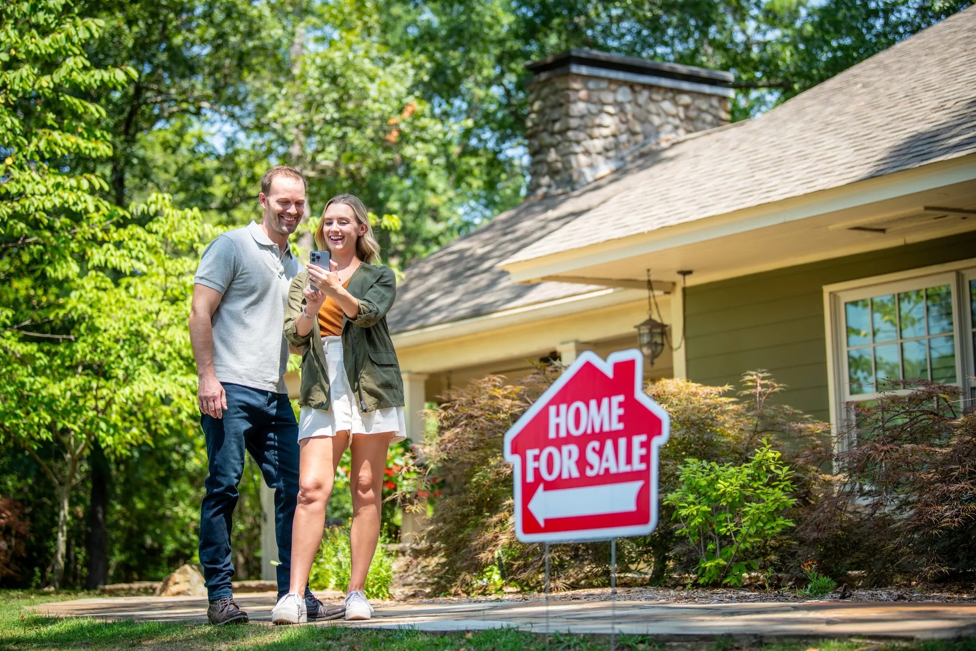 Man and woman standing in front of house for sale. Man and woman standing in front of house for sale.