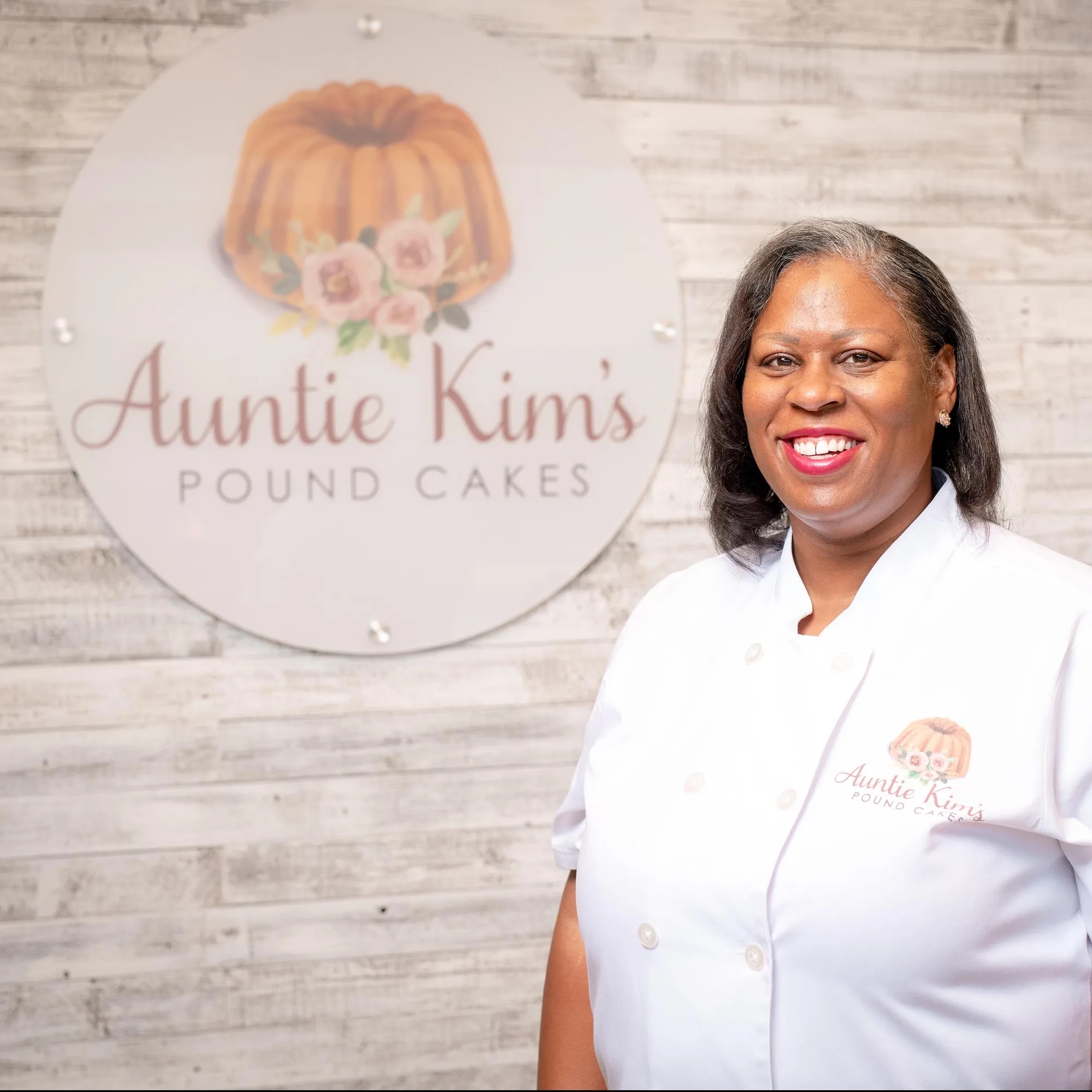 Auntie Kim in front of her business sign