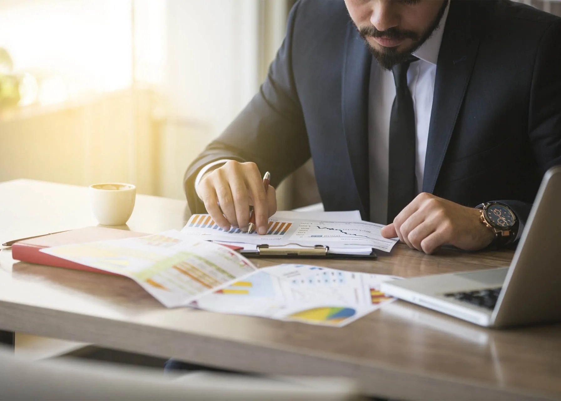 Man sitting at a table looking at spreadsheets. 