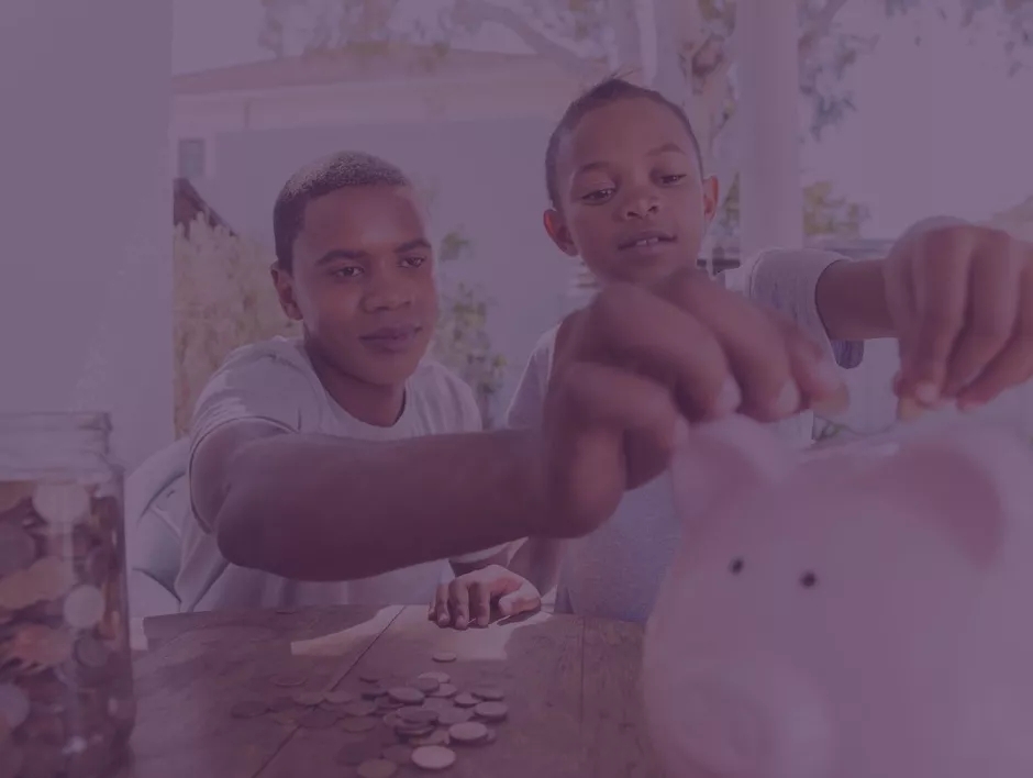 Two kids depositing coins into piggy bank.