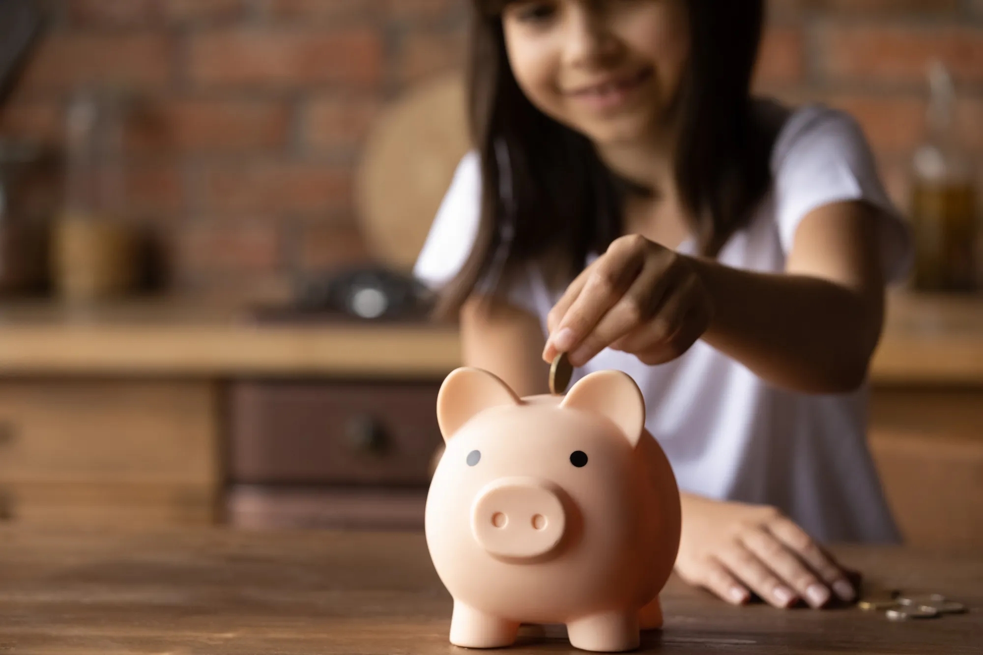 Two kids depositing coins into piggy bank. Two kids depositing coins into piggy bank.