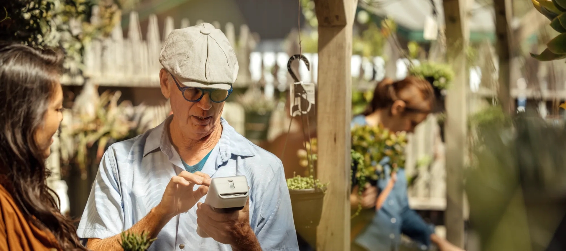 Flower shop owner using a clover handheld Flower shop owner using a clover handheld