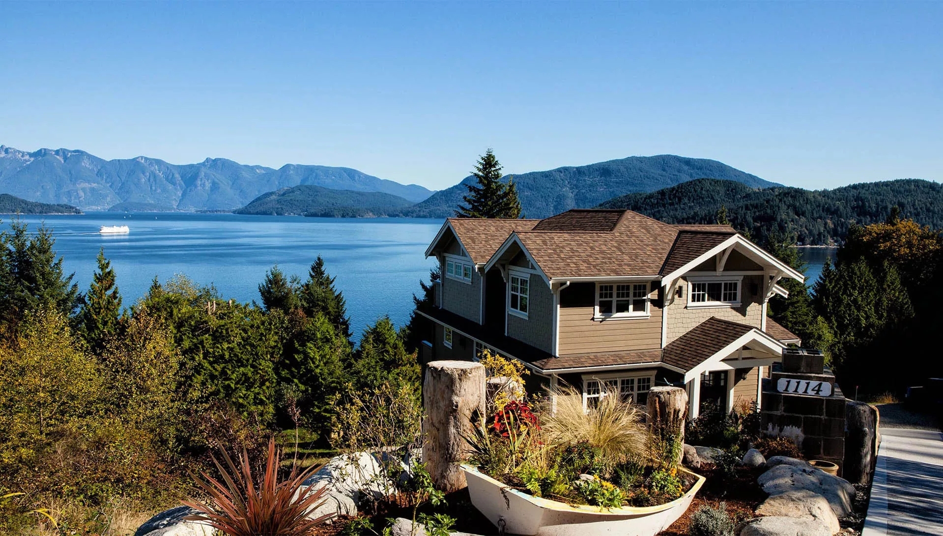 A large, new home overlooking a mountain valley filled as a lake.