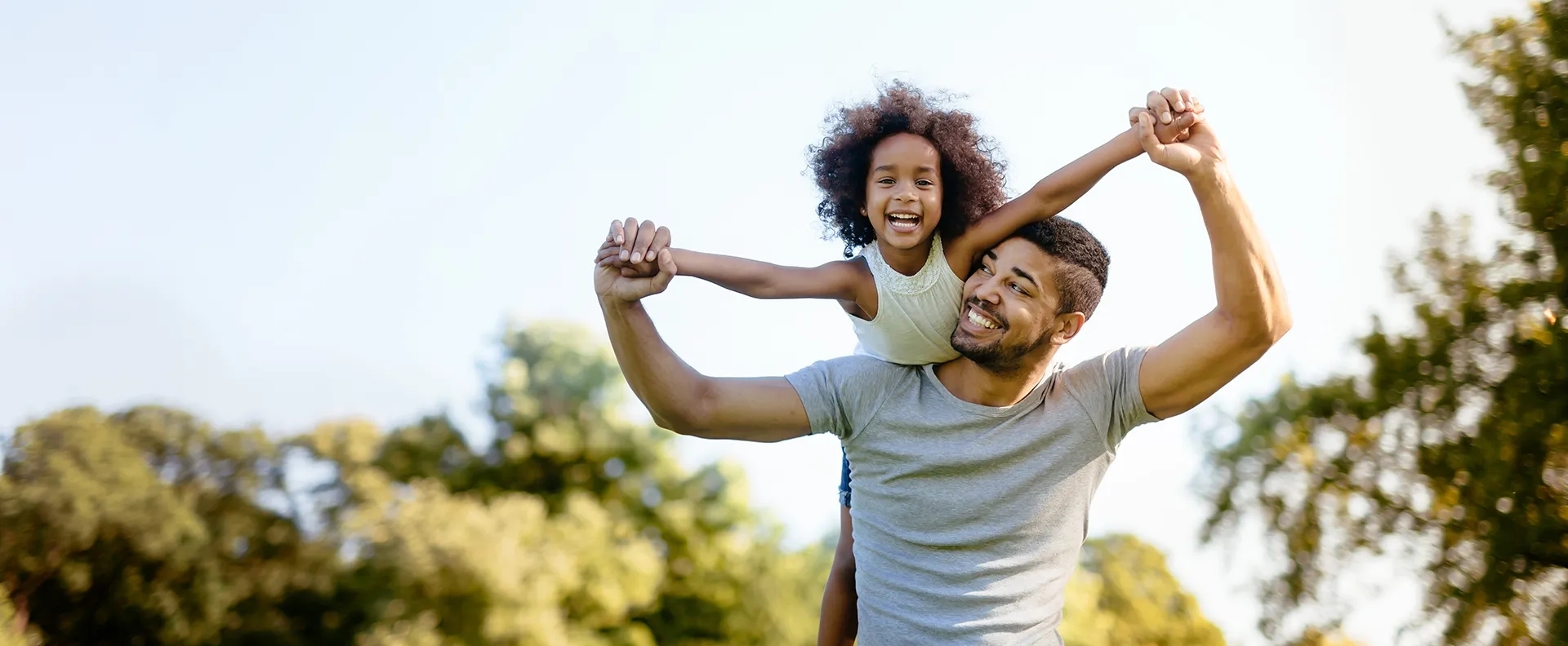 Man and Child playing airplane outside